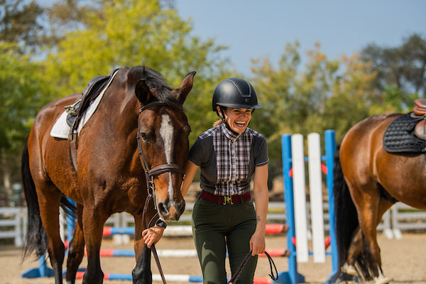 Woman laughing while walking horse