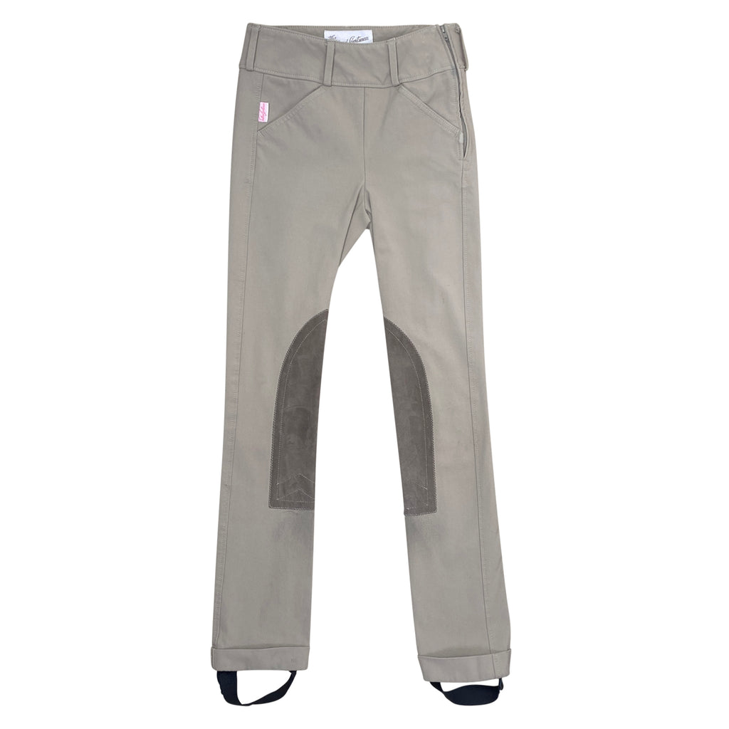 Tan riding pants with knee patches on a white background