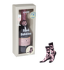 Bottle of Rosé Bubbles with packaging and zebra-patterned socks on a white background