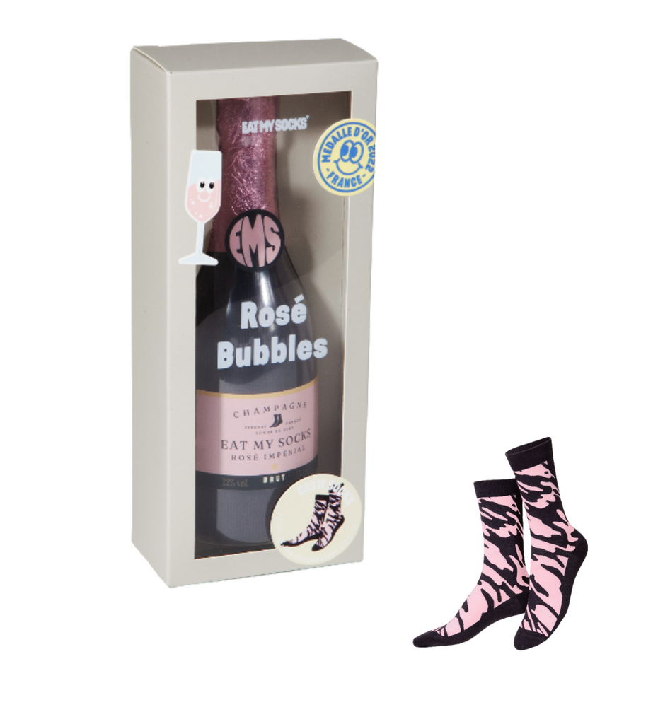 Bottle of Rosé Bubbles with packaging and zebra-patterned socks on a white background